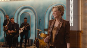 Jean Smart as Deborah Vance standing on the set of her late night show with a band behind her in 'Hacks'