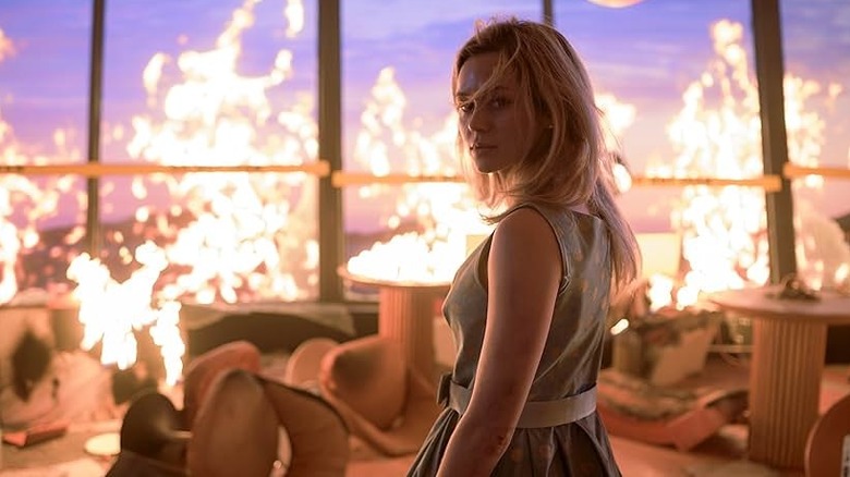 Brec Bassinger standing amidst flaming rubble in Final Destination Bloodlines