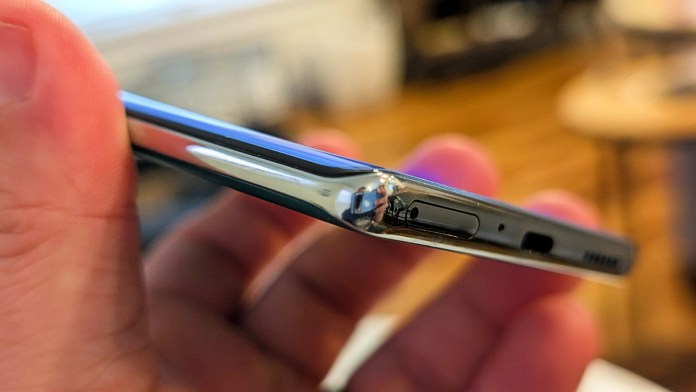 Close-up view of the TECNO Camon 40 Pro 5G showing the side profile with buttons and ports, held in a hand.
