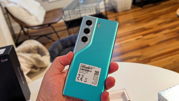 A person holding the TECNO Camon 40 Pro 5G smartphone, showcasing its sleek design with a matte back finish and a vertical camera setup.