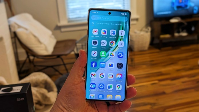 A person holding the TECNO Camon 40 Pro 5G smartphone displaying its app interface, with a cozy home setting in the background.