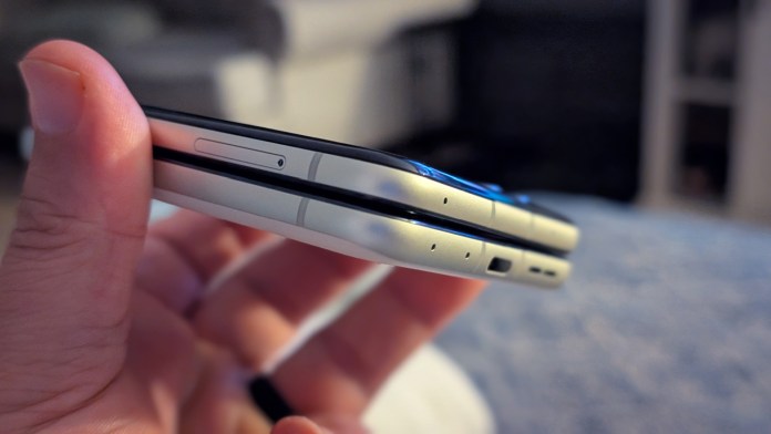 Close-up of two Motorola Razr phones being held side by side, showcasing their sleek design and close profile.