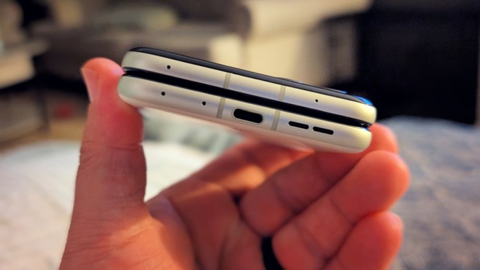 Close-up view of the Motorola Razr 2025 held in hand, showcasing its sleek design and ports on the bottom edge.