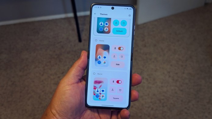 A person holding a smartphone displaying customization options for themes, featuring various color schemes and toggle buttons in a user-friendly interface.