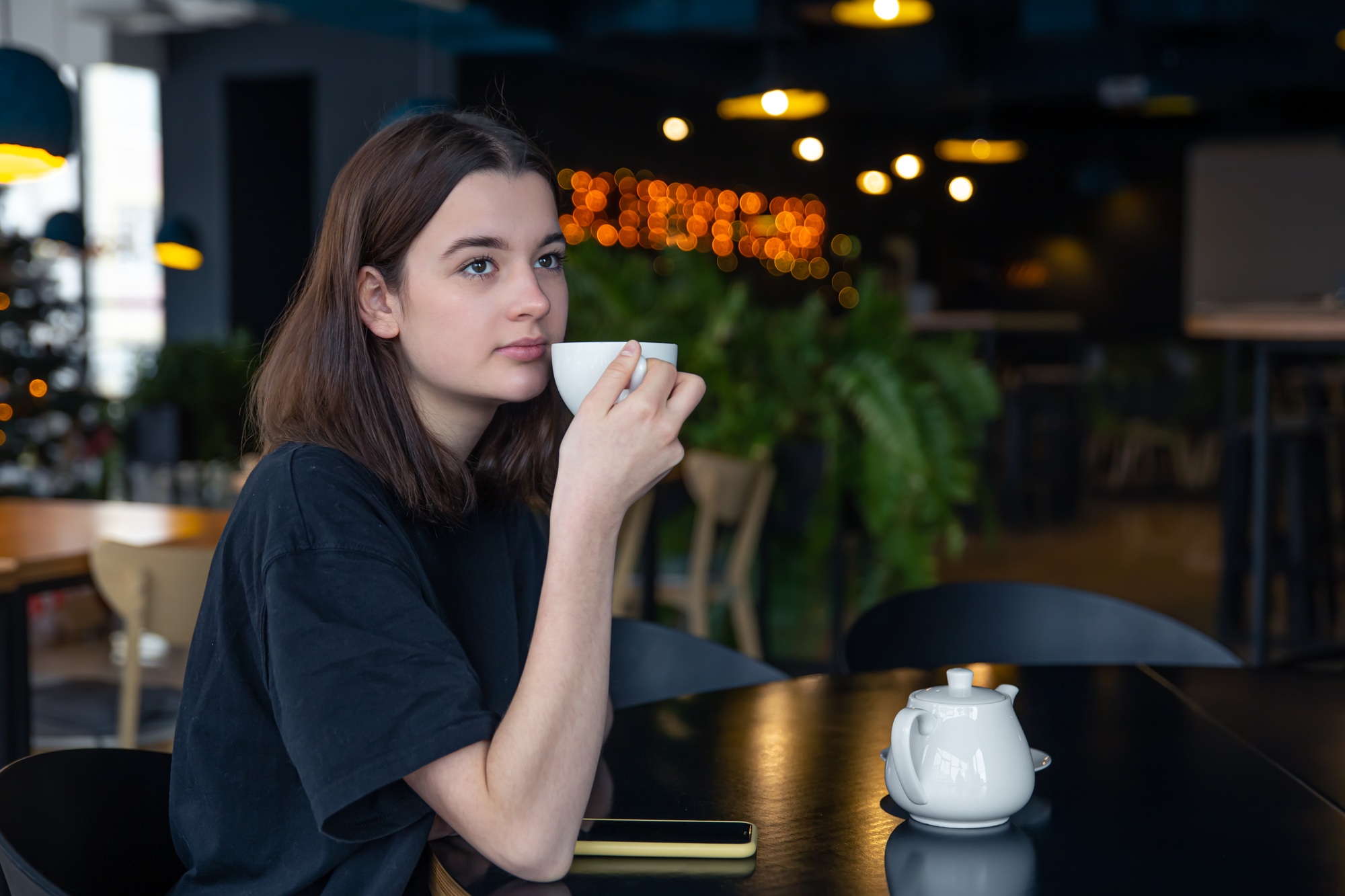 Portrait of a young woman with a cup of tea in a cafe.