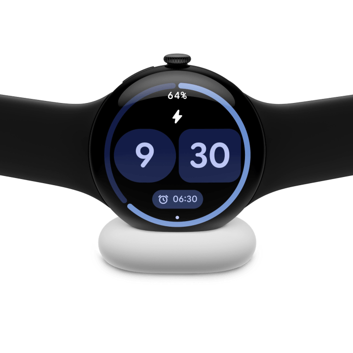 A close-up of a smartwatch displaying the time and battery level, placed on a wireless charging dock.