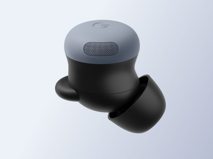 A close-up view of the Pixel Buds 2a, featuring a sleek black design with a light gray top and a mesh speaker cover, set against a light background.