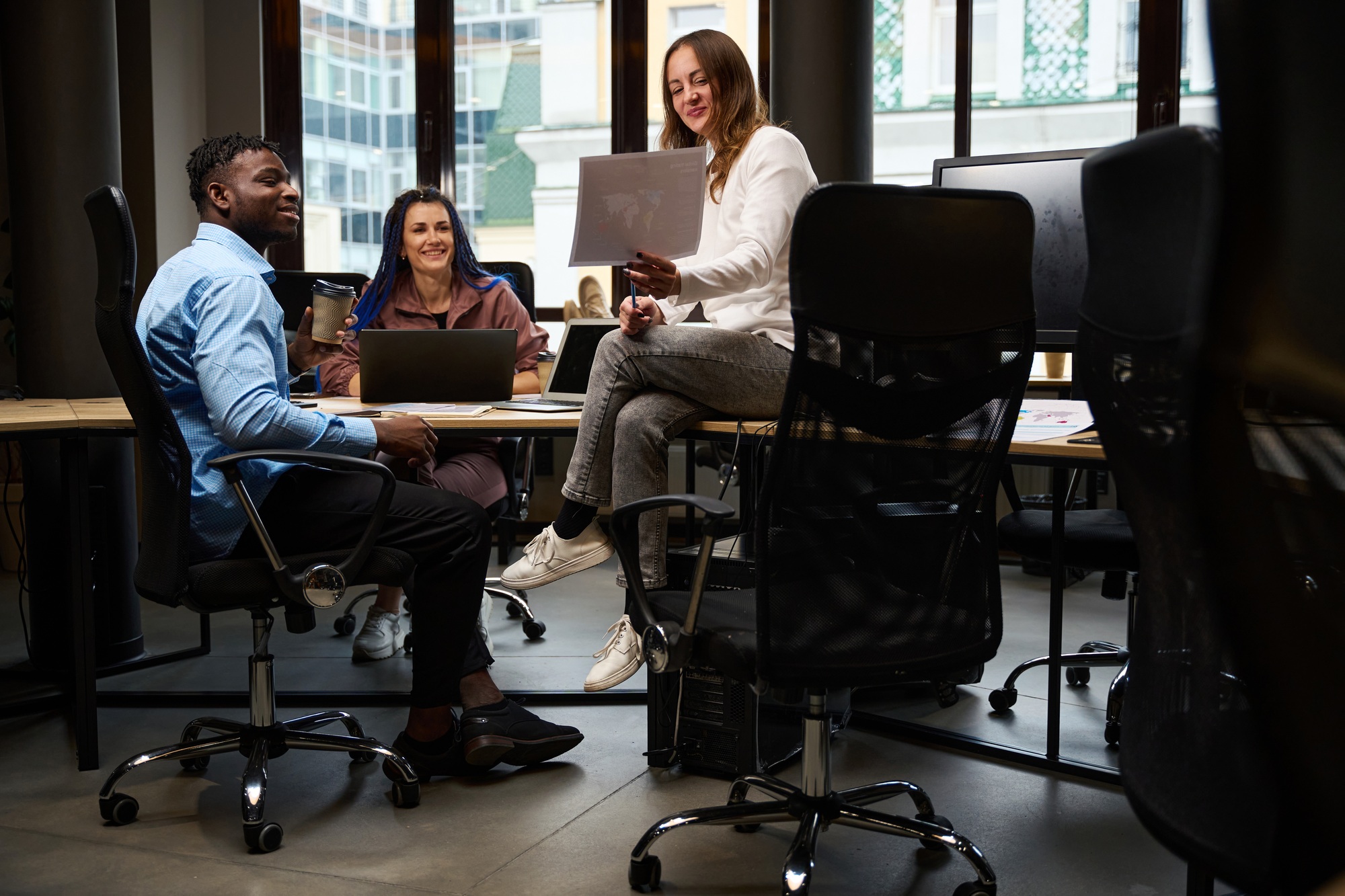 Male and female colleagues sitting in cozy chairs discussing new company logo
