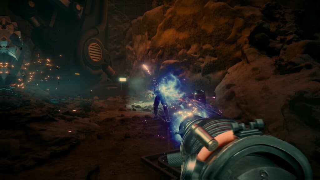 A firefight in Fallout New Vegas shows a blue energy beam striking an armored enemy in a rocky cave. Sparks light up the dark tunnel as the weapon fires